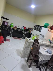 eine Küche mit einem Tisch und einem Rucksack auf einem Stuhl in der Unterkunft Alex in Castanhal