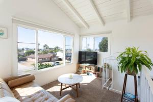 a living room with a couch and a tv at North PB Gem Close to the Beach in San Diego