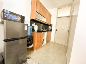 een keuken met een roestvrijstalen koelkast en houten kasten bij tsavo roysambu in Nairobi