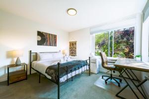 a bedroom with a bed and a desk and a window at Perch - Wallingford Comfort in Seattle
