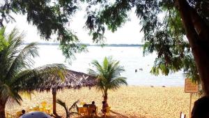 een uitzicht op een strand met mensen die in het water zwemmen bij Pousada Texas Club in Panorama +5 foto's