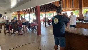 Een man aan een bar in een restaurant. bij Pousada Texas Club in Panorama