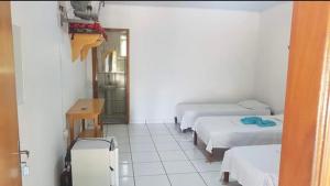 een kamer met drie bedden en een koffer erin bij Pousada Texas Club in Panorama