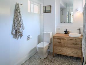 a bathroom with a toilet and a sink and a mirror at Main Beach home overlooking Yuraygir National Park in Yamba