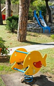 a yellow toy dog on a playground in a park at Hotel Villa Adriana in Monterosso al Mare