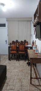 a room with chairs and a table and a tv at Apto aconchegante pitangueiras in Guarujá +6 photos