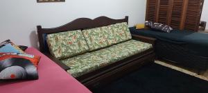 a bedroom with a bed and a bench with a mattress at Apto aconchegante pitangueiras in Guarujá