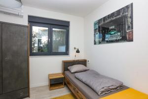 ein kleines Schlafzimmer mit einem Bett und einem Fenster in der Unterkunft Family-friendly apartments with swimming pool Murter - 22942 in Murter + 16 Fotos
