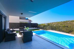 ein Haus mit Swimmingpool und Terrasse in der Unterkunft Family-friendly apartments with swimming pool Murter - 22942 in Murter