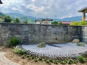 a stone wall with two rocks in front of it at MYOJI HOUSE 2 Traditional Japanese Stay in Katsuragi +40 photos