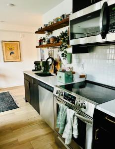 a kitchen with a stainless steel stove top oven at Heart of Fishtown with parking! in Philadelphia