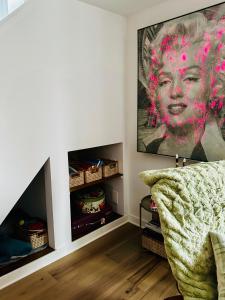a living room with a couch and a painting on the wall at Heart of Fishtown with parking! in Philadelphia