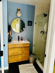 a bathroom with a sink and a shower with a mirror at Heart of Fishtown with parking! in Philadelphia