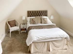 a bedroom with a large bed and a chair at The Old Forge in Alnwick +5 photos