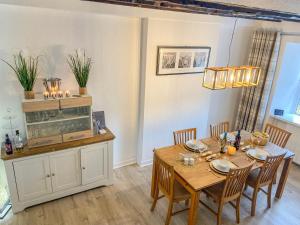 Un comedor con mesa y sillas en Holly Cottage, en Palnackie