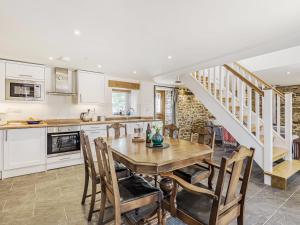 a kitchen and dining room with a wooden table and chairs at The Stables - Cottage in Bryngwyn +21 photos