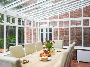 a conservatory with a wooden table and chairs at Home Farm House in Dorrington