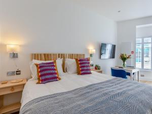a bedroom with a large bed with colorful pillows at Belgrave Sands Apartment in Torquay +13 photos