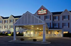 a hotel with a sign for a community inn at Country Inn & Suites by Radisson, Watertown, SD in Watertown