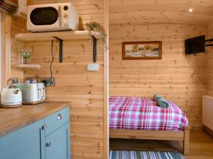a bedroom with a bed and a tv on a wall at Ewe Lodge - Uk48824 in Kirby Misperton