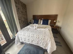 een slaapkamer met een wit bed met twee harten erop bij Sicilia con Terraza y chimenea in Santeagueda