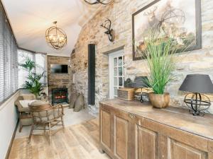 a living room with a stone wall and a fireplace at Narrowgates Cottage in Barrowford