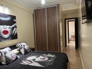 a bedroom with a bed with a poster of a woman at Appartement Haut Standing in El Jadida +7 photos