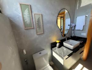 a bathroom with a sink and a toilet and a mirror at Cabanas 3quedas - Gonçalves-MG in Gonçalves