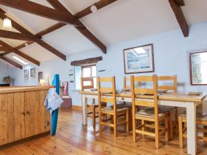 a dining room with a wooden table and chairs at New England-Uk12750 in Menheniot
