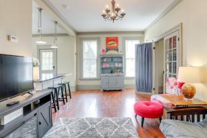 a living room with a television and a table with chairs at Franklin Home with Deck, Creek Views Walk to Shops in Franklin
