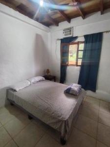 a bedroom with a bed in a room with a window at Iguana Hostel in Montañita