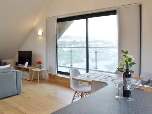 a living room with a table and a large window at Lyndhurst in Perranporth
