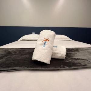 a pair of towels sitting on top of a bed at Hotel Salute in Taguatinga
