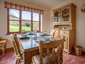 una sala da pranzo con tavolo, sedie e una finestra di Lephin Cottage a Glendale