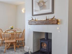 a living room with a fireplace and a table at The Cottage Highfield in Rothbury