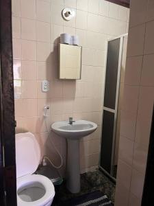 a bathroom with a toilet and a sink at Sorriso Do Sol Suites in Arraial do Cabo