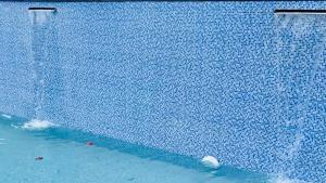a blue tiled swimming pool with water in it at Elephant House The Royal Resorts & Villas in Sultan Bathery +7 photos