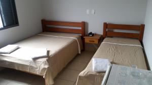 Santo AnastácioにあるFlorença Hotelのテーブル付きの小さな部屋のベッド2台 +104枚の写真