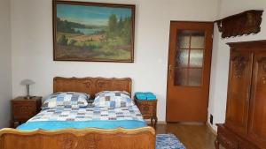 ビャウォヴィエジャにあるVilla Kniaziaのベッドルーム1室(ベッド1台付)が備わります。壁には絵画が飾られています。