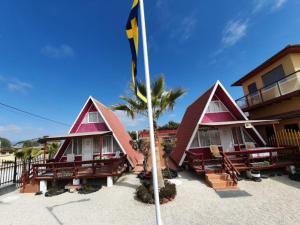 a couple of cottages with a flag in front of them at Tropical Cabaña B in Coquimbo