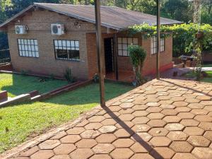a brick house with a yard with a patio at RINCÓN Del DESCANSO in Oberá