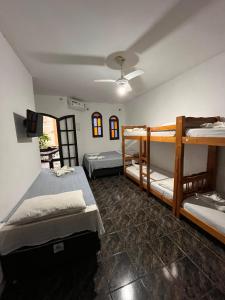 a room with three bunk beds and a tv at Sorriso Do Sol Suites in Arraial do Cabo