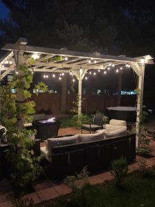 a pergola with lights and a couch in a yard at The Cozy nest in Englewood