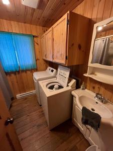 a bathroom with a sink and a washing machine at Relax On the Lake Waterfront with Hot Tub in Chertsey