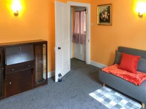 a living room with a couch and a tv at 5 Rose Cottages in Sandhurst