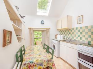 Una cocina con una mesa y sillas y un fregadero. en The Cottage, en Slickly