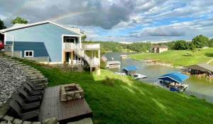 a house on a river with a rainbow in the background at Lake Therapy at The ARK | Gameroom, Hot Tub, Dock in Williamstown