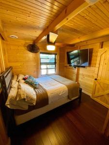 a bedroom with a bed in a wooden cabin at Lake Therapy at The ARK | Gameroom, Hot Tub, Dock in Williamstown