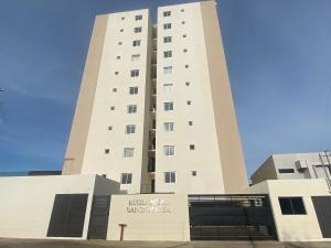 un alto edificio bianco con un cartello sopra di Encantador apartamento de 2 dormitorios a Luque