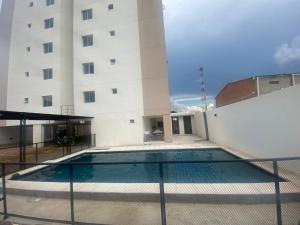 una piscina di fronte a un edificio di Encantador apartamento de 2 dormitorios a Luque